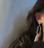 Modern abstract silhouette earrings with a lustrous pearl drop, combining artistic design with timeless pearl elegance.