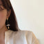 Unique baroque pearl earrings with a gold-textured stud and dangling detail, a marriage of rustic charm and modern design.