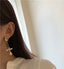 Unique baroque pearl earrings with a gold-textured stud and dangling detail, a marriage of rustic charm and modern design.