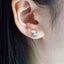 Tiny pterodactyl dragon stud earrings in sterling silver with 14k gold plating and cubic zirconia accents.