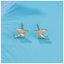 Tiny pterodactyl dragon stud earrings in sterling silver with 14k gold plating and cubic zirconia accents.