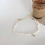 an elegant freshwater pearl necklace on a creamy backdrop, showcasing the unique iridescent pendant.