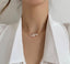 A graceful pearl necklace against a backdrop of delicate white fabric, epitomizing elegance.