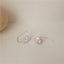 Delicate petal-shaped pearl drop earrings with a thin gold wire, reflecting artisanal elegance and natural charm.