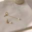 Subtle yet sophisticated minimalist pearl drop earrings with an elegant gold finish, perfect for any occasion.