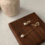 Subtle yet sophisticated minimalist pearl drop earrings with an elegant gold finish, perfect for any occasion.