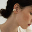 A magnetic pearl cuff earring with a cascading chain of pearls, combining classic elegance with innovative design.