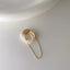 A magnetic pearl cuff earring with a cascading chain of pearls, combining classic elegance with innovative design.
