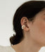 A magnetic pearl cuff earring with a cascading chain of pearls, combining classic elegance with innovative design.